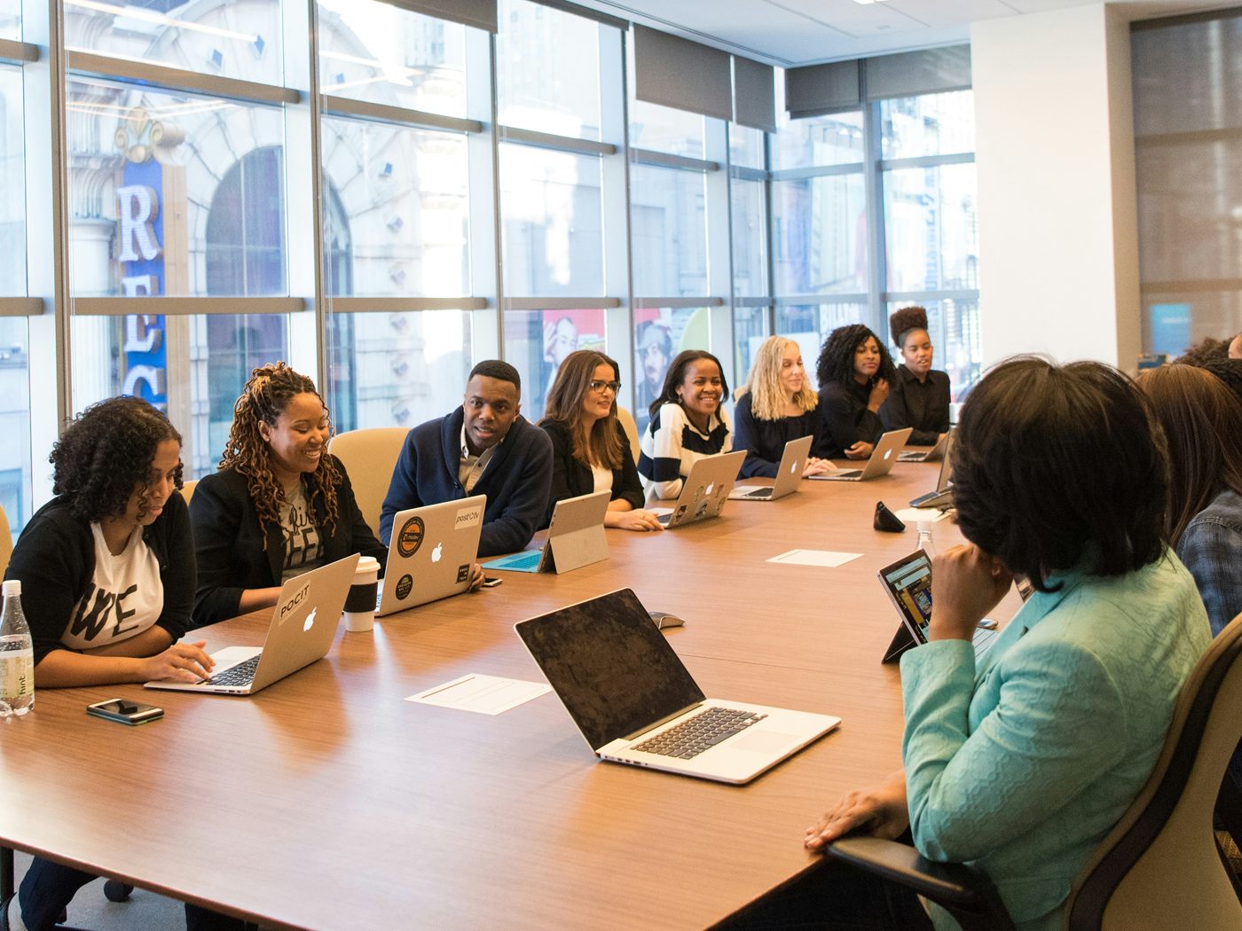 Diverse professional team meeting around a conference table for Str8Up GFI agent training and portal access.
